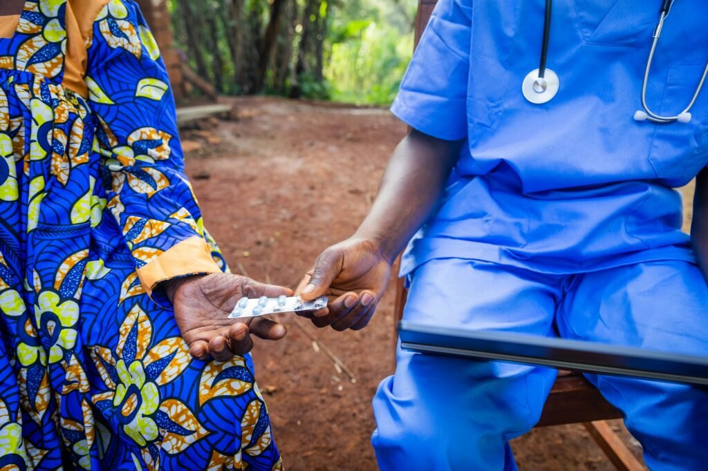 A doctor gives medicines to an elderly patient while explaining the prescription from the tablet